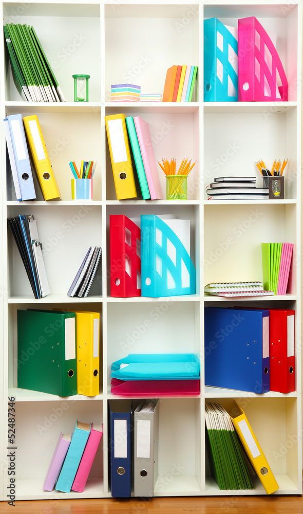 White office shelves with different stationery, close up