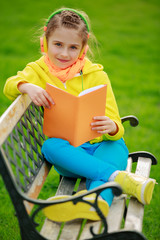 Wall Mural - Listening music - girl with a book resting on the bench