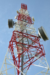 Tower with cell phone antenna system against blue sky