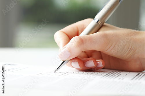 Fotomural Businesswoman writing on a form