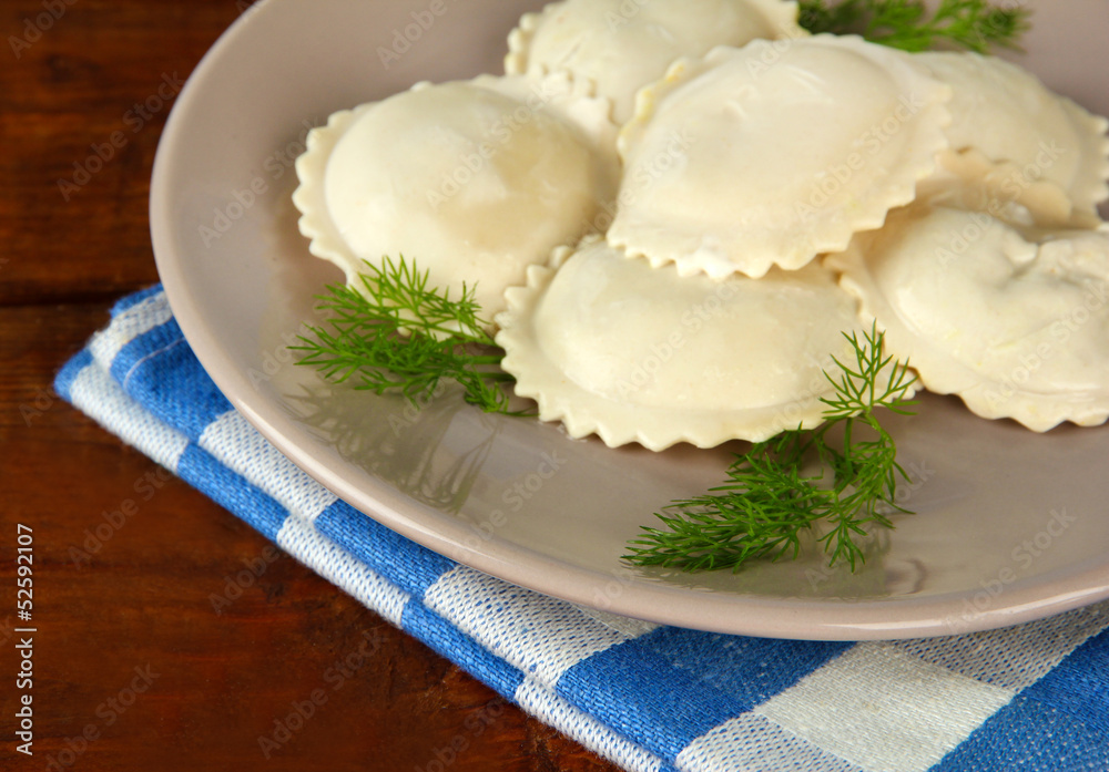 Tasty dumplings on plate, on wooden table