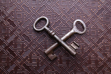 Two Crossed Rusty Keys On Leather Pattern Background