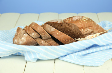 Hot tasty bread, on wooden table, on color background