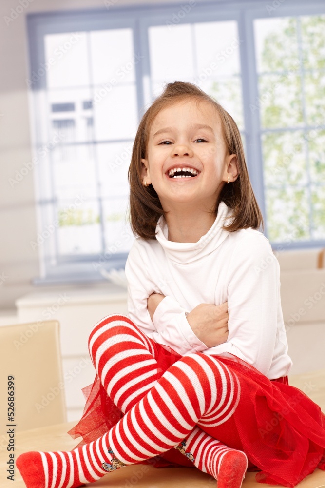 Happy little girl laughing in tailor seat Stock Photo | Adobe Stock