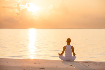 Caucasian woman practicing yoga at seashore