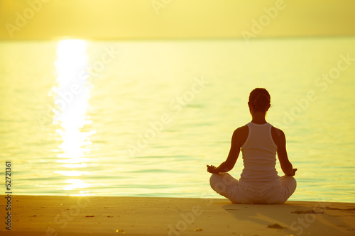 Caucasian woman practicing yoga at seashore - 52721361
