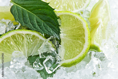 Fototapeta na wymiar Slices of a lime and leaves of mint