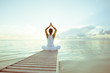 Leinwandbild Motiv Caucasian woman practicing yoga at seashore