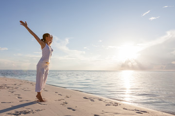 Caucasian woman practicing yoga at seashore