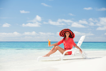 Fashion woman drinking cocktail on the beach