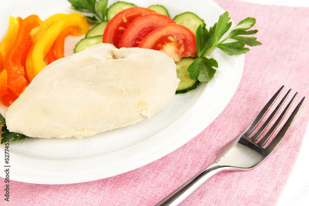 Boiled chicken breast on plate with vegetables close up