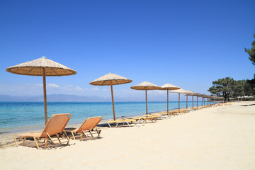 Wall Mural - Umbrellas and recliners by the sea