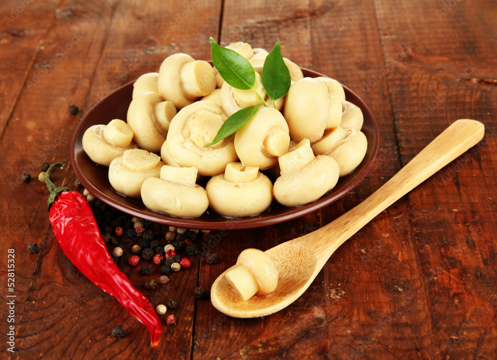 Mushrooms on plate, on wooden background