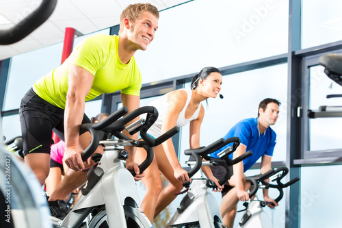 Láminas group doing sport Spinning in the gym for fitness