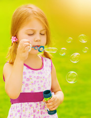 Wall Mural - Baby girl blowing soap bubbles