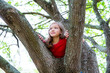 children kid girl playing climbing to a tree in a park