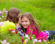 happy twin sister girls playing whispering ear in meadow
