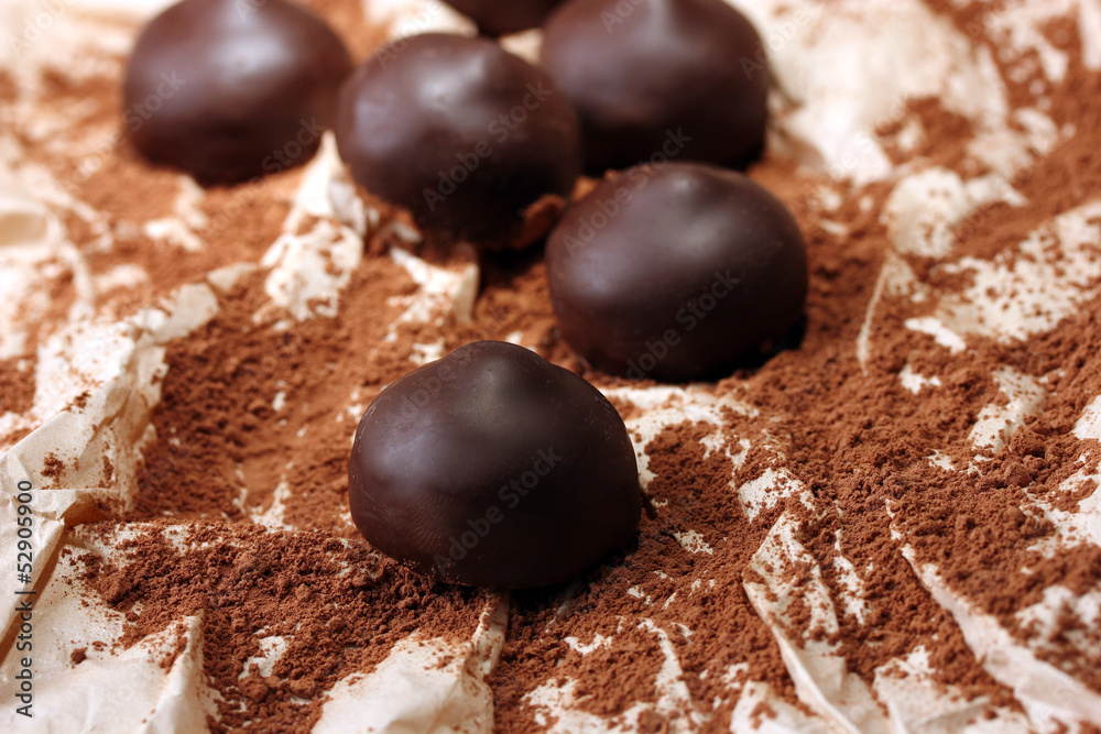 Chocolate candies with cocoa powder, close up