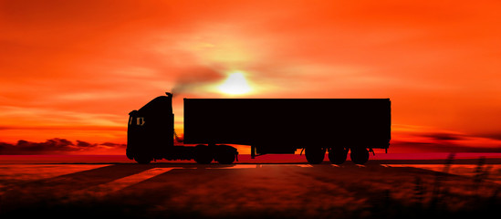 Silhouette of a truck on a highway at sunset