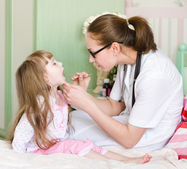 Pediatrician examining little girl's throat