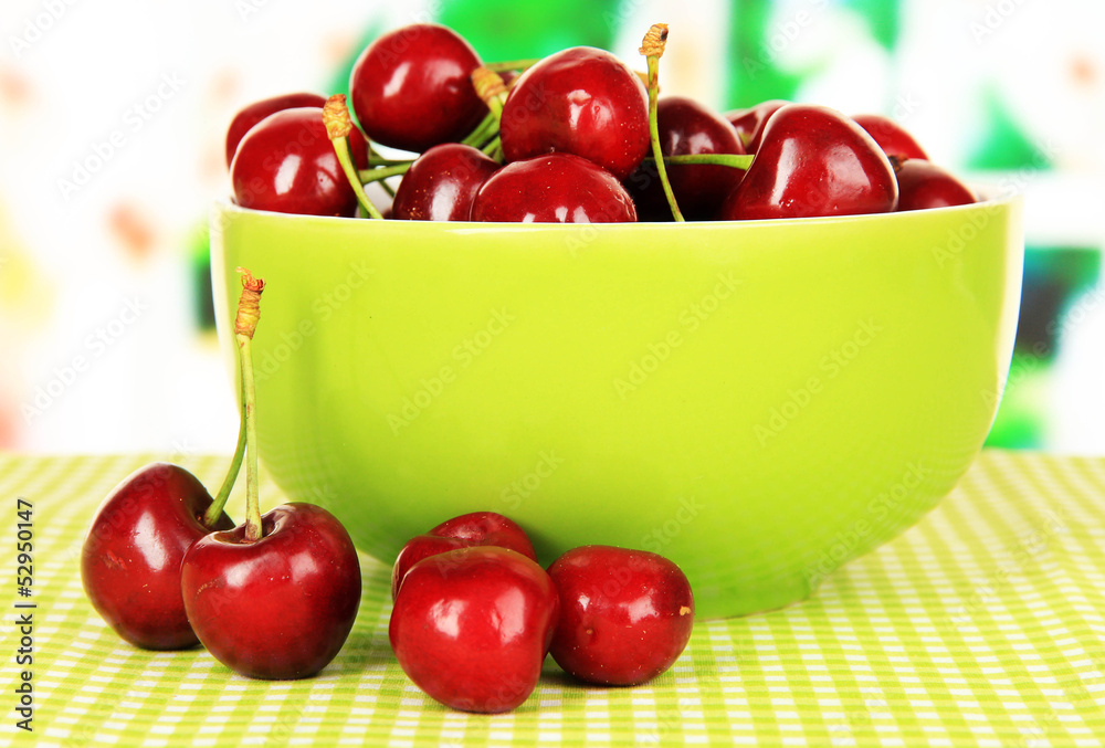 Cherry berries in bowl on table in room