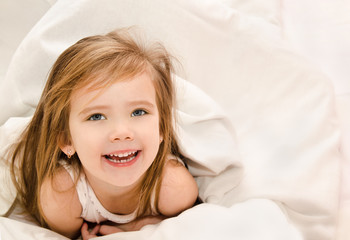 Adorable little girl awaked up in her bed