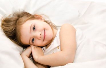 Adorable little girl awaked up in her bed