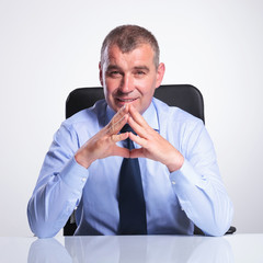 Wall Mural - old business man at desk with hands together