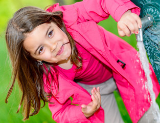 Wall Mural - cute kid about to drink water in a fountain