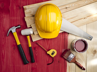 red wood floor with a brush, paint, hammer and yellow helmet