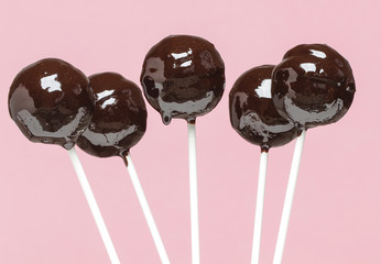 Wall Mural - Chocolate cake pops on pink background. Selective focus.