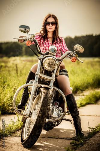 Naklejka na drzwi Dziewczyna siedząca na motorze na tle polany