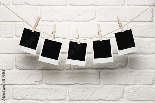 Naklejka nad blat kuchenny Blank photos hanging on a clothesline over brick wall background