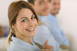 © goodluz - Cheerful girl in office showing thumbs up