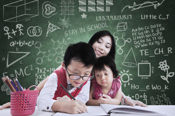 Boy and his sister study in class with teacher