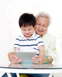 © szeyuen - Asian grandmother and grandson using tablet computer