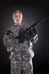 Portrait Of A Mature Soldier Holding Gun