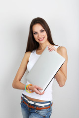 Wall Mural - Beautiful young woman with laptop in room