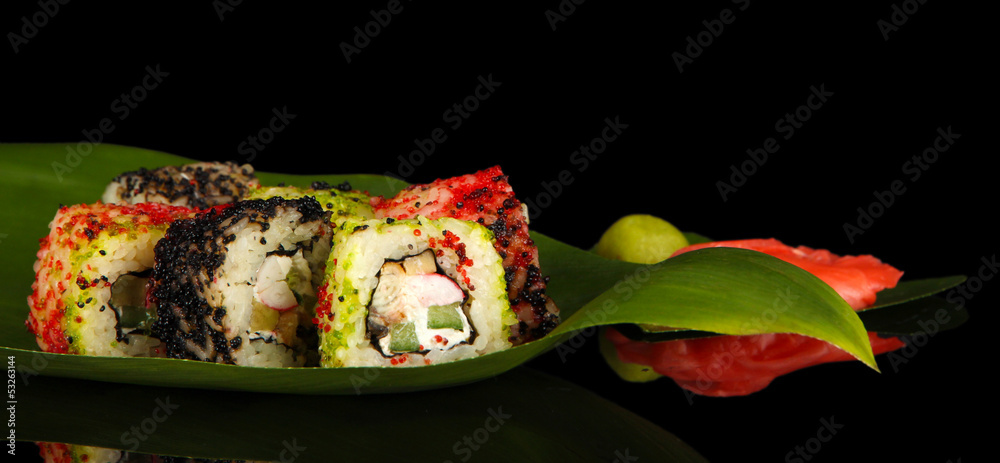 Tasty Maki sushi - Roll on green leaf on dark background