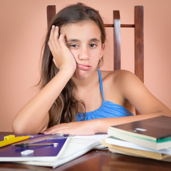 Bored and tired hispanic student with a desk full of books