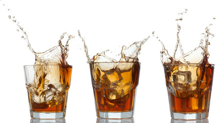 whiskey set splashing out of glass on white