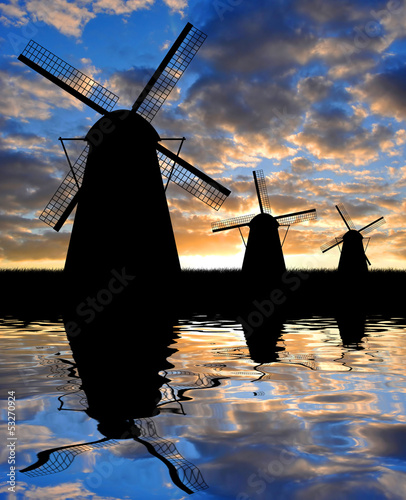Obraz w ramie Silhouettes of windmills in the sunset