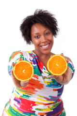 Wall Mural - Overweight young black woman holding  orange slices - African pe