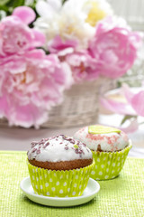 Wall Mural - Cupcakes on rustic wooden table. Stunning peony flowers in the b