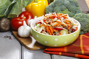 Fresh vegetable salad in green dotted bowl. Raw vegetables and f