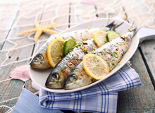 Three Grilled Sardines On A Platter Outdoors