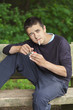 Boy with a cigarette on a bench in the park