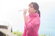 Young woman drinking from a plastic bottle of water