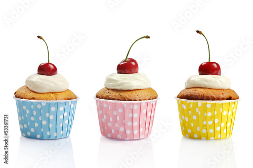 Fototapeta na wymiar Three cupcakes and cherries