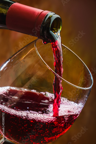 Fototapeta na wymiar Wine pours into the glass of the bottle